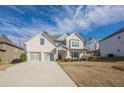 Charming two-story brick home featuring a three-car garage and a well-manicured front lawn with a long driveway at 614 Denali Dr, Mableton, GA 30126