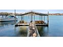 Picturesque boat dock on the lake with chairs, boat lift, and stunning water views at 7530 Heard Rd, Cumming, GA 30041