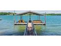 Dock featuring a sun deck, wooden chairs, and boat storage on a tranquil lake at 7530 Heard Rd, Cumming, GA 30041