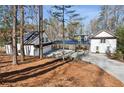 Charming white home featuring a covered carport, lush green landscaping and a driveway at 7530 Heard Rd, Cumming, GA 30041