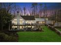 Beautiful two-story home with a spacious deck, manicured lawn, and lush trees at 7530 Heard Rd, Cumming, GA 30041