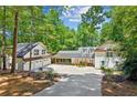 Beautiful two-story home featuring white siding, black trim, and a drive-through portico connecting the house and garage at 7530 Heard Rd, Cumming, GA 30041