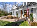 Home's inviting entrance features a stone pathway leading to a wood door and the charming landscape complements the house at 6170 Wellington Ct, Cumming, GA 30040