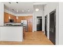 Open kitchen and dining area with stainless steel appliances, hardwood floors, and dark-colored doors at 978 North Ne Ave # 307, Atlanta, GA 30306