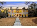 Elegant two-story home with a symmetrical facade, warm exterior lighting, and a well-maintained front lawn at 4132 Carmain Ne Dr, Atlanta, GA 30342
