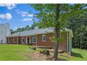 Brick home with a side view featuring a tree in the front yard and a well-maintained lawn at 9035 Teal Ln, Jonesboro, GA 30236