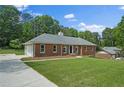 Classic brick home with an attached garage and a long driveway, showcasing its curb appeal at 9035 Teal Ln, Jonesboro, GA 30236