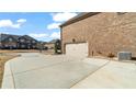 Side view of a home with a wide concrete driveway leading to an attached two-car garage at 5669 Casa Blanca Ln, Atlanta, GA 30331