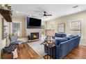 Bright living room boasts a stone fireplace, hardwood floors, a ceiling fan, and a comfortable blue sofa at 1985 Lois Pl, Atlanta, GA 30318