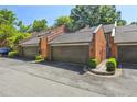 Three car garages in a row on brick buildings with dark roofs and an asphalt driveway at 17 Willow Ne Gln, Atlanta, GA 30342