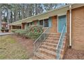 Brick stairs lead to a charming blue front door with matching shutters and green landscaping at 2941 Pine Valley Cir, East Point, GA 30344