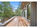 Expansive porch with natural wood floors, sleek black railings, and scenic views of the surrounding trees at 96 Sheridan Dr, Atlanta, GA 30305