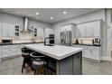 Modern kitchen with a large center island, white cabinetry, stainless steel appliances, and hardwood floors at 3220 Celebration Blvd, Suwanee, GA 30024