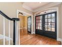 Elegant foyer featuring hardwood floors, staircase, and glass paned french doors at 3894 Stone Lake Nw Dr, Kennesaw, GA 30152