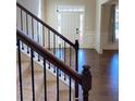 Bright foyer featuring hardwood floors, staircase with black wrought iron balusters, and a white front door at 526 Blue Mountain Rise, Canton, GA 30114