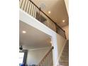 Upward view of staircase featuring black wrought iron balusters, carpet on the steps, and natural light at 526 Blue Mountain Rise, Canton, GA 30114