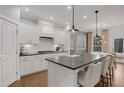 Elegant kitchen featuring white cabinets, granite countertops, an island with barstool seating, and stainless appliances at 6095 Marigold Way, Atlanta, GA 30349