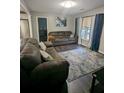 Cozy living room featuring wood floors, a patterned rug, two sofas, and natural light from the window at 6977 Eunice Dr, Riverdale, GA 30274