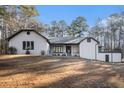 Charming single-story home with a textured facade, complemented by mature trees and a spacious front yard at 1675 Dodson Sw Dr, Atlanta, GA 30311