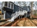 Stylish home featuring a white staircase leading to a second-story deck, combining modern design with outdoor living at 493 Willow Springs Dr, Marietta, GA 30068