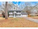 Charming two-story home featuring a fresh white paint, black shutters, and an attached garage at 2328 Carnes Rd, Jonesboro, GA 30236