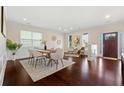 Bright dining room with hardwood floors, wainscotting, a modern table, and comfortable seating near the front door at 250 High Court Way, Locust Grove, GA 30248