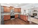 Well-equipped kitchen features stainless steel appliances, granite countertops, and hardwood floors open to the living room at 250 High Court Way, Locust Grove, GA 30248