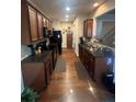 Long and narrow kitchen design with stainless steel appliances, wooden cabinets, and granite countertops at 1426 Brookmere Way, Cumming, GA 30040