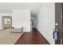 Elegant foyer with hardwood floors, wainscoting detail, and view to carpeted living room at 615 Ceremony Way, Acworth, GA 30102