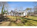 Beautiful exterior of home with metal roof and large front yard with fire pit at 915 Homer Rd, Woodstock, GA 30188