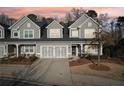Charming townhouse with a two-car garage, neutral gray siding, and well-maintained landscaping at sunset at 334 Cherokee Station Cir, Woodstock, GA 30188