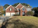 Lovely two-story red brick home featuring a well-manicured front yard and a two-car garage at 3381 Walkers Ridge Rd, Dacula, GA 30019