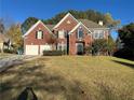 Attractive two-story red brick home featuring a lush front yard and a spacious two-car garage at 3381 Walkers Ridge Rd, Dacula, GA 30019
