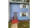 View of a two-story home with blue siding, white trim, and a red stairway to the entry door at 6950 Oakhill Se Cir, Austell, GA 30168