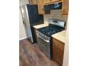 Close-up of kitchen with stainless steel appliances and wood cabinets at 2303 Pine Tree Trl, Atlanta, GA 30349