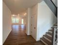 Bright foyer leading to an open floor plan with hardwood floors and a staircase with black metal railings at 691 Calvet Way, Cumming, GA 30041