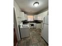 Compact kitchen with white cabinets, stove, and refrigerator at 1686 Valencia Rd, Decatur, GA 30032