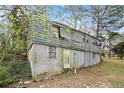 View of the rear of the two-story home with a basement, visible windows, and siding at 2057 Akron Se Dr, Atlanta, GA 30315