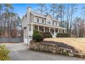 View of a two-story home with a front porch, attached garage, and stone retaining wall at 194 Preston Nw Pl, Dallas, GA 30157