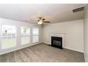 Spacious living room with a fireplace, carpet flooring, and ample natural light at 5792 Village Loop, Fairburn, GA 30213