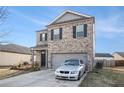 Attractive two-story home with brick facade, two car garage, and concrete driveway at 2126 Sawgrass Dr, Hampton, GA 30228