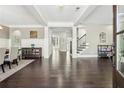 Bright entryway with dark hardwood floors, white columns, a staircase, and an adjacent dining area at 4520 Valence Dr, Cumming, GA 30040