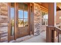 Inviting entryway showcasing a wood door with glass panels, complemented by stone and brick accents at 4520 Valence Dr, Cumming, GA 30040
