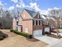 Spacious brick home featuring a two-car garage, and a well-manicured lawn, creating a welcoming curb appeal at 4901 Village Green Dr, Roswell, GA 30075
