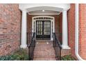 Elegant front entrance featuring brick stairs and walkway, double doors, and classic white columns at 4901 Village Green Dr, Roswell, GA 30075