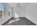 Bright dining room featuring a modern light fixture, fresh white paint, and gray wood flooring at 2250 Deer Oaks Trl, Lawrenceville, GA 30044