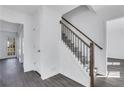 Bright hallway featuring updated staircase with modern wood and wrought iron banister and gray wood flooring at 2250 Deer Oaks Trl, Lawrenceville, GA 30044