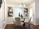 Dining area features modern chandelier, glass table, and chic artwork for a stylish meal setting at 904 Wentworth Ct, Alpharetta, GA 30022