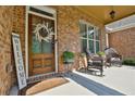 Inviting front porch with a rocking chair and a welcoming wreath on the door at 102 Glenmill Way, Woodstock, GA 30188