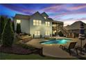 Backyard oasis features a sparkling pool with waterfall feature, patio, and lush landscaping at 102 Glenmill Way, Woodstock, GA 30188